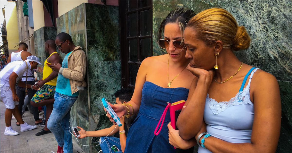 Usuarios de Internet en Cuba intentan conectarse en un punto wifi © CiberCuba