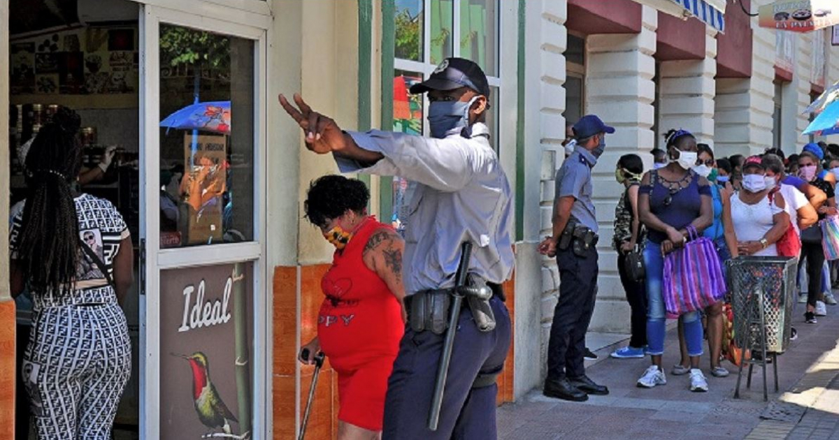 La policía controla una cola para acceder a una tienda durante las restricciones impuestas por el coronavirus. © Periódico Venceremos