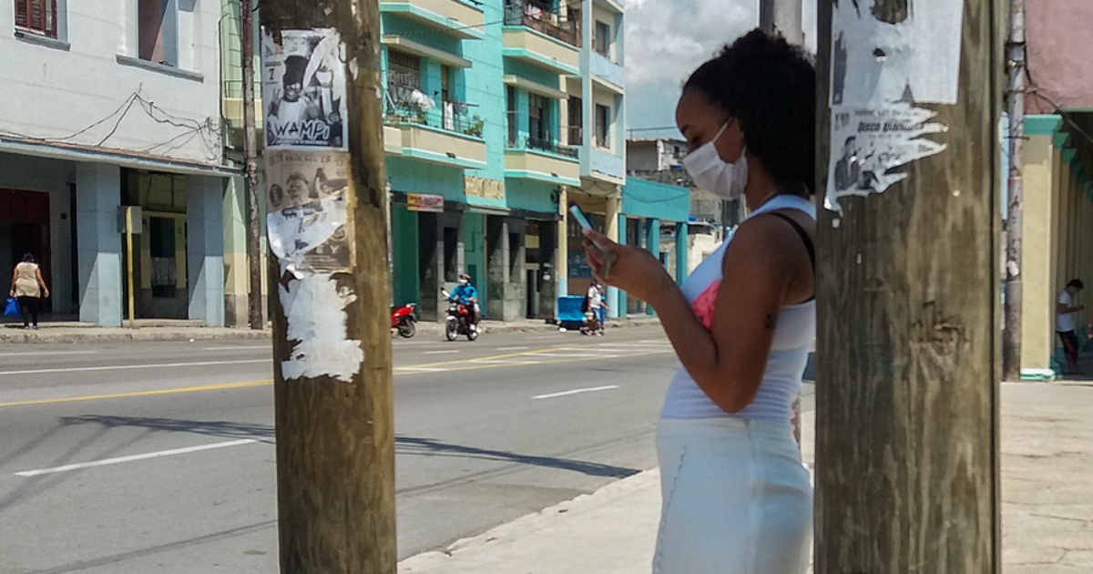 Cubana mira su celular en La Habana, la provincia con más cobertura 4G. © CiberCuba