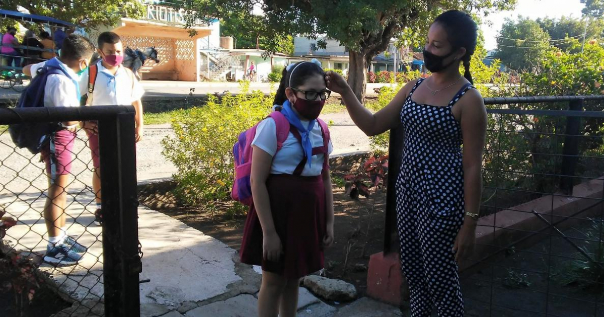 Maestra toma la temperatura a una niña a la entrada de la escuela © Facebook/ Sergio González López 