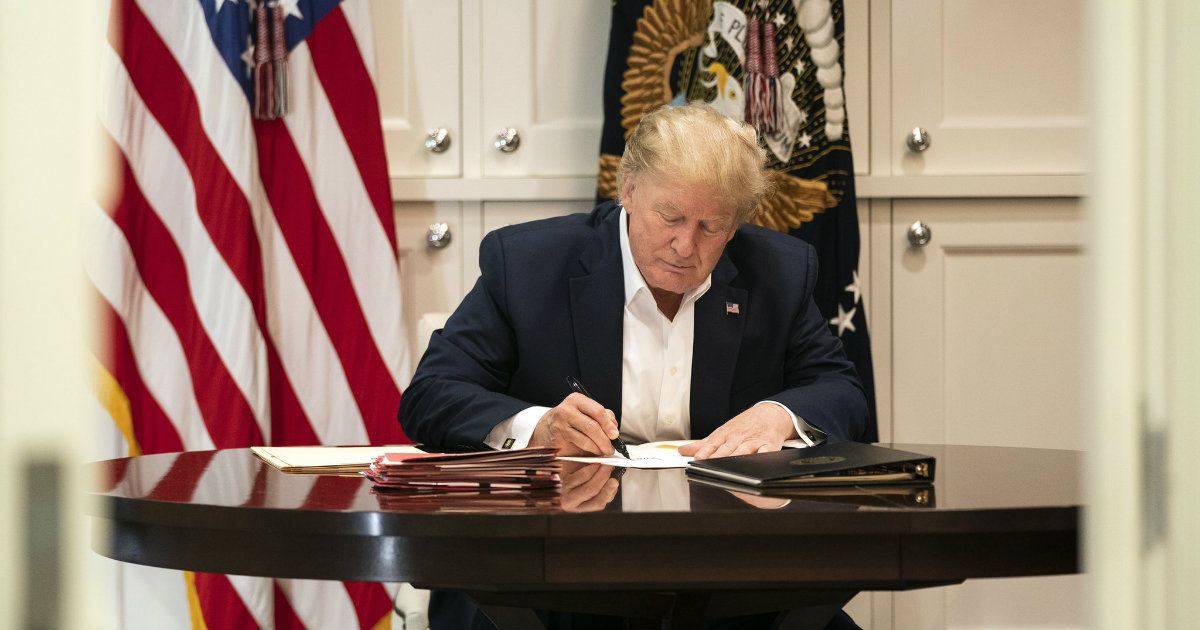 Donald Trump escribe o firma un documento © White House