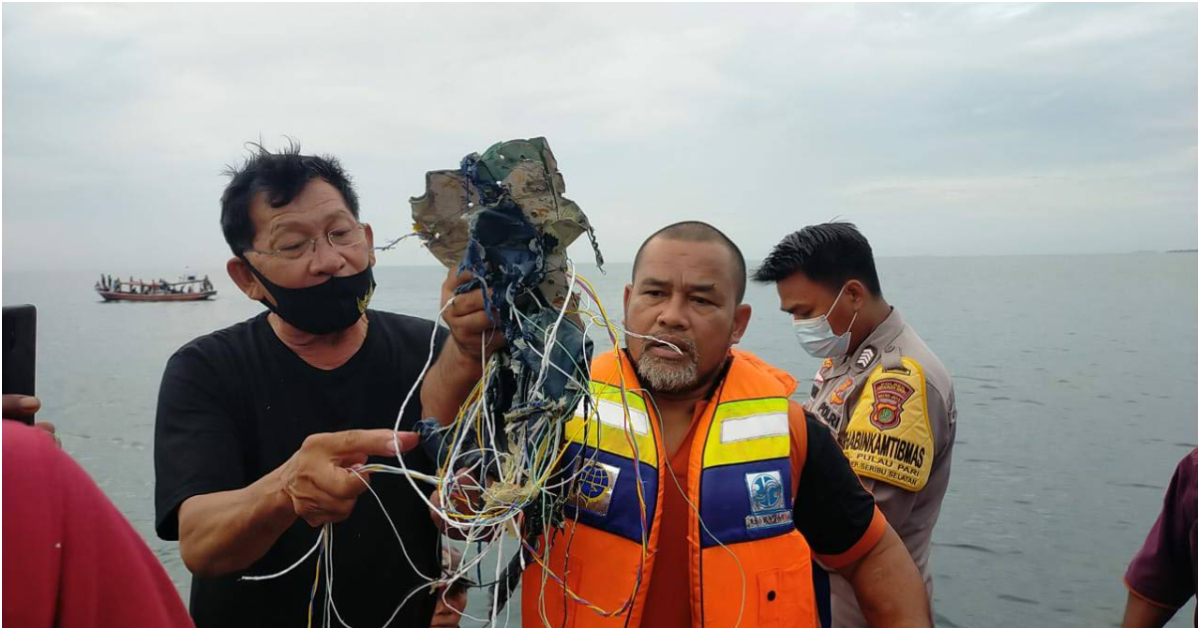 pescadores indonesios con restos del avión estrellado en sus manos © Aviation For Aviators / captura de pantalla