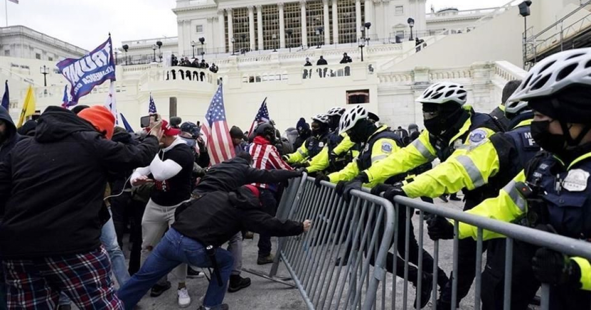 Policías y seguidores de Donald Trump durante el asalto al Capitolio © Twitter / Bruce Leshan