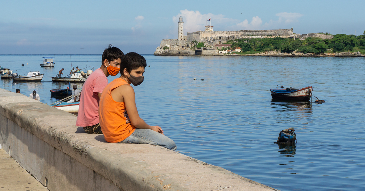 Niños cubanos sentados en el malecón de la Avenida del Puerto en La Habana © CiberCuba 