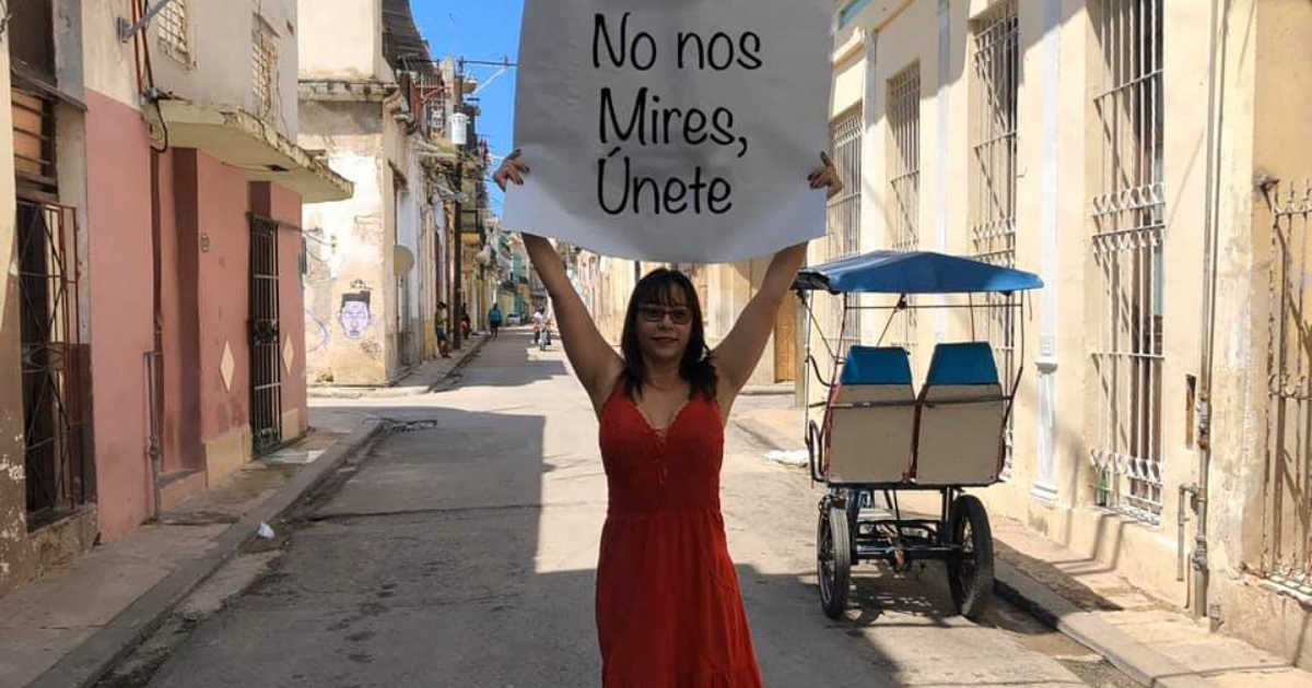 Iliana Hernández en la calle con un cartel que dice "No nos mires, únete" © Facebook/Iliana Hernández 
