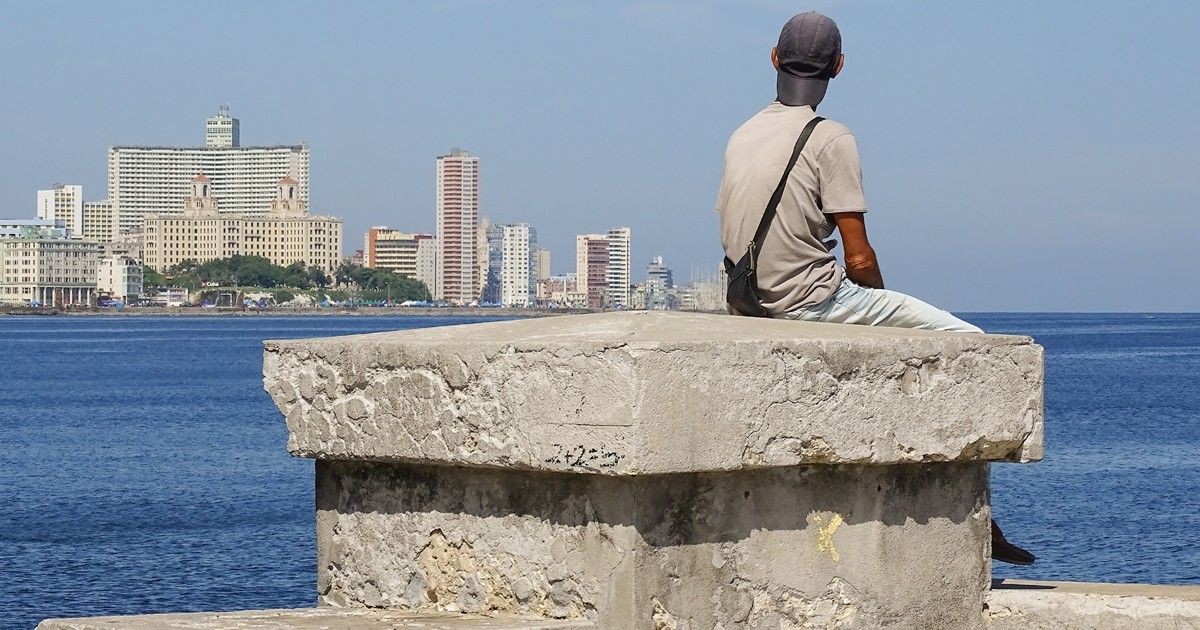 Joven sentado en el muro del Malecón de La Habana © CiberCuba
