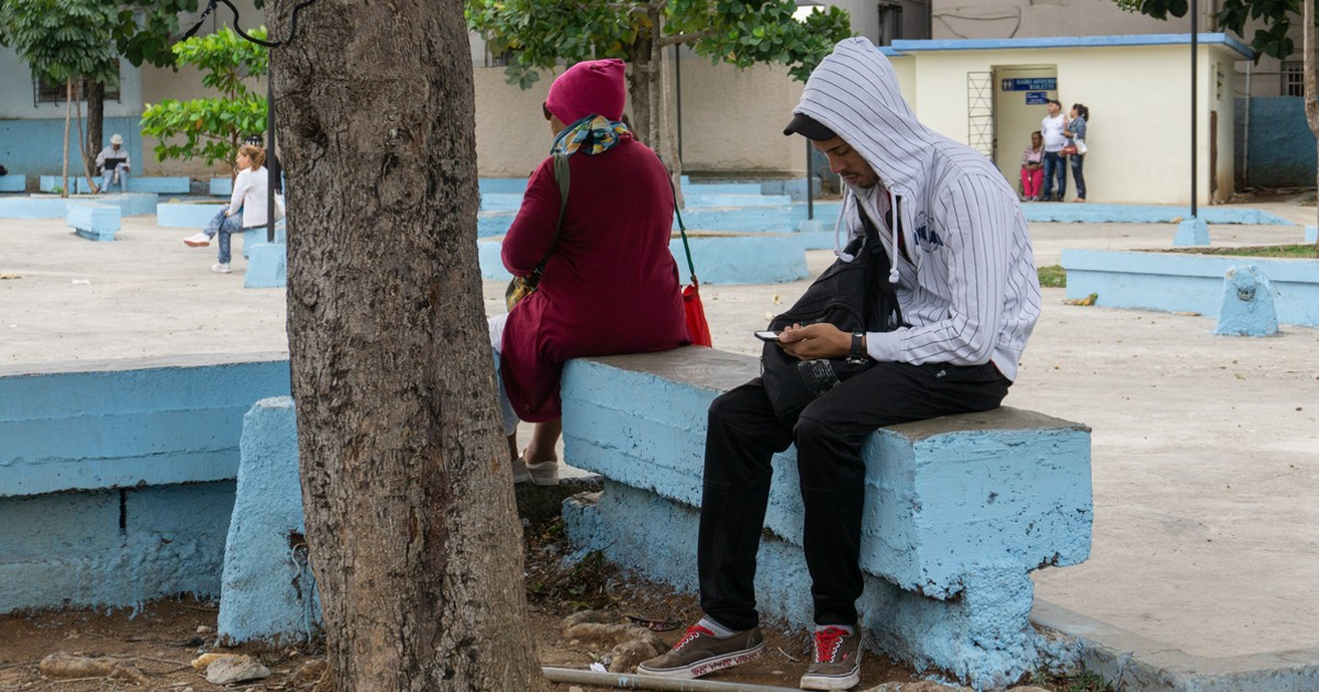 Joven pendiente de su celular en Cuba. © CiberCuba