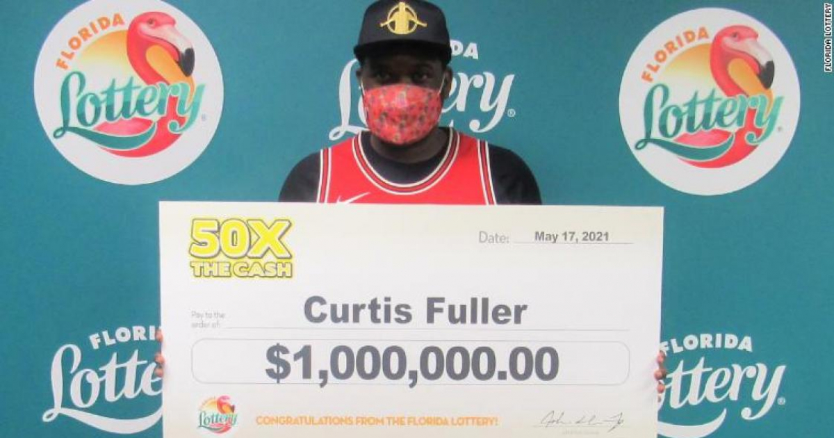 Curtis Fuller posa con un cheque simbólico de un millón de dólares © Lotería de Florida