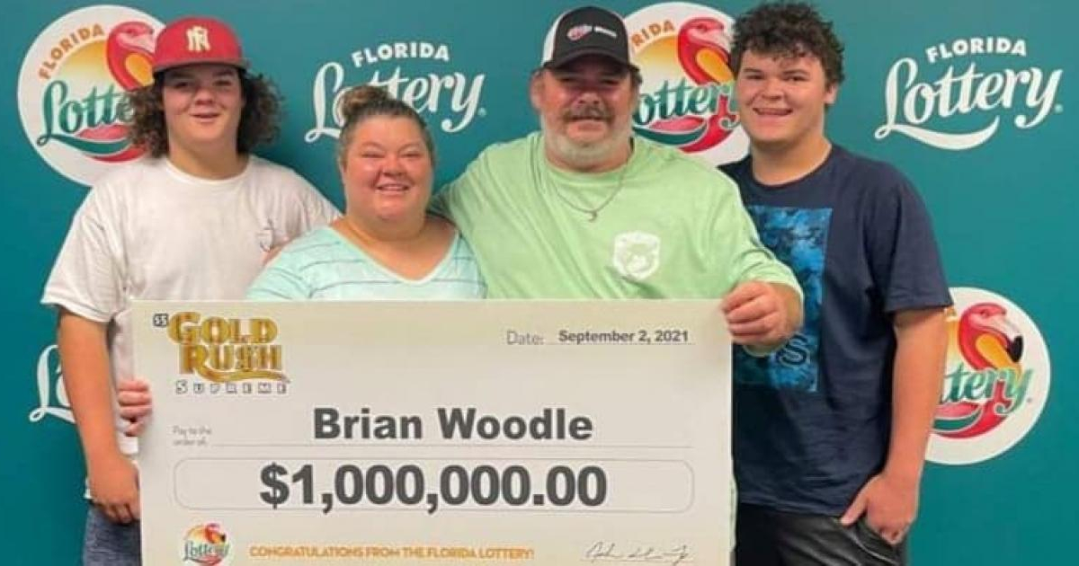 Brian Woodle y su familia con el cheque simbólico de un millón © Lotería de Florida