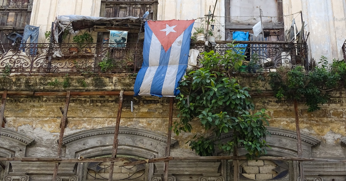 Bandera cubana en un balcón en ruinoso estado (referencia) © CiberCuba