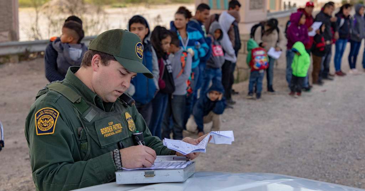 Agente de la Patrulla Fronteriza de EEUU e inmigrantes © Picryl
