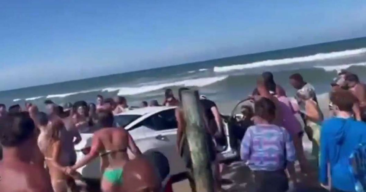 Bañistas rodean el auto detenido a la orilla del mar © Captura de video de Instagram / foxnews