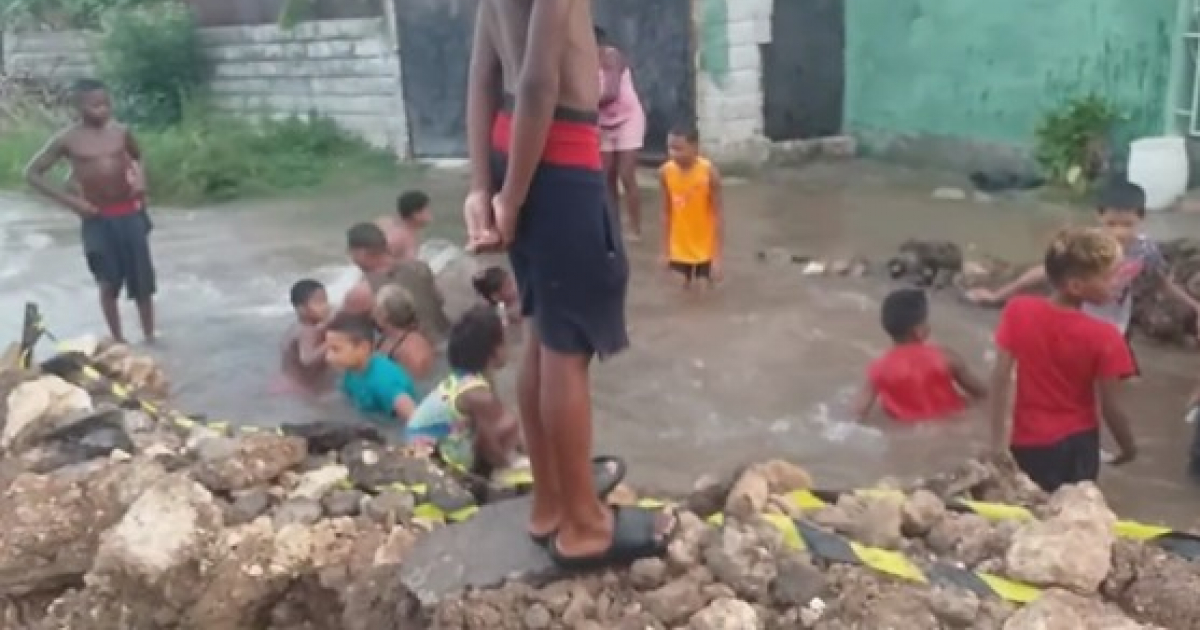 Niños bañándose en bache lleno de agua sucia en Marianao, La Habana. © Captura de video de Jacob Morris en Twitter
