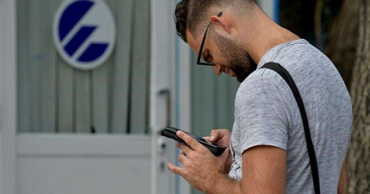 Cubano conectado desde su celular frente a oficinas de ETECSA (imagen de referencia) © ACN