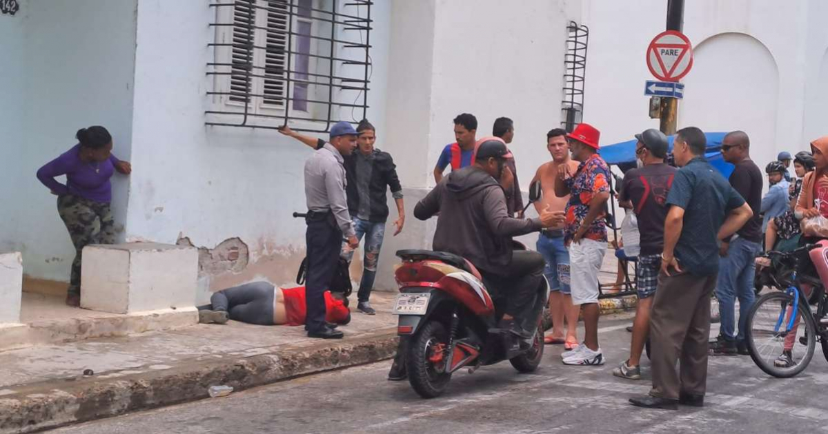 Ladrón tumbado en la acera, rodeado de un policía y más personas © Agustín Garcells / Facebook