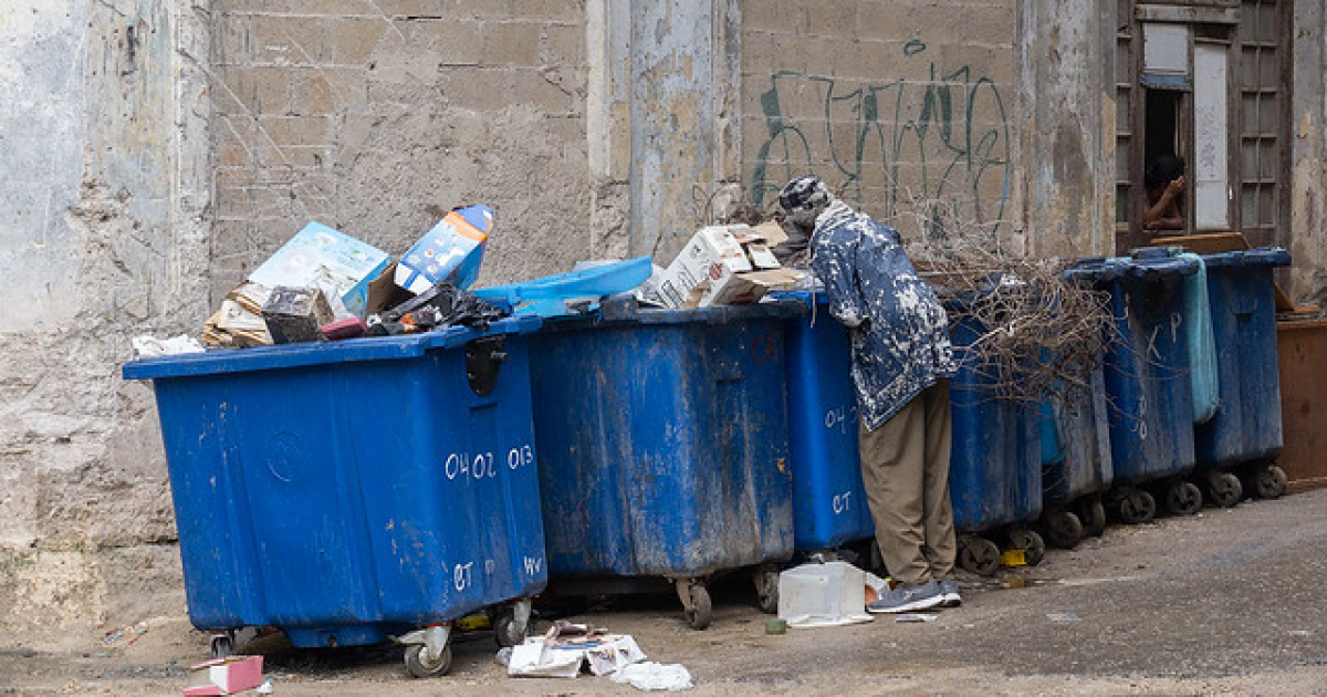 Cubano registrando un latón de basura © CiberCuba
