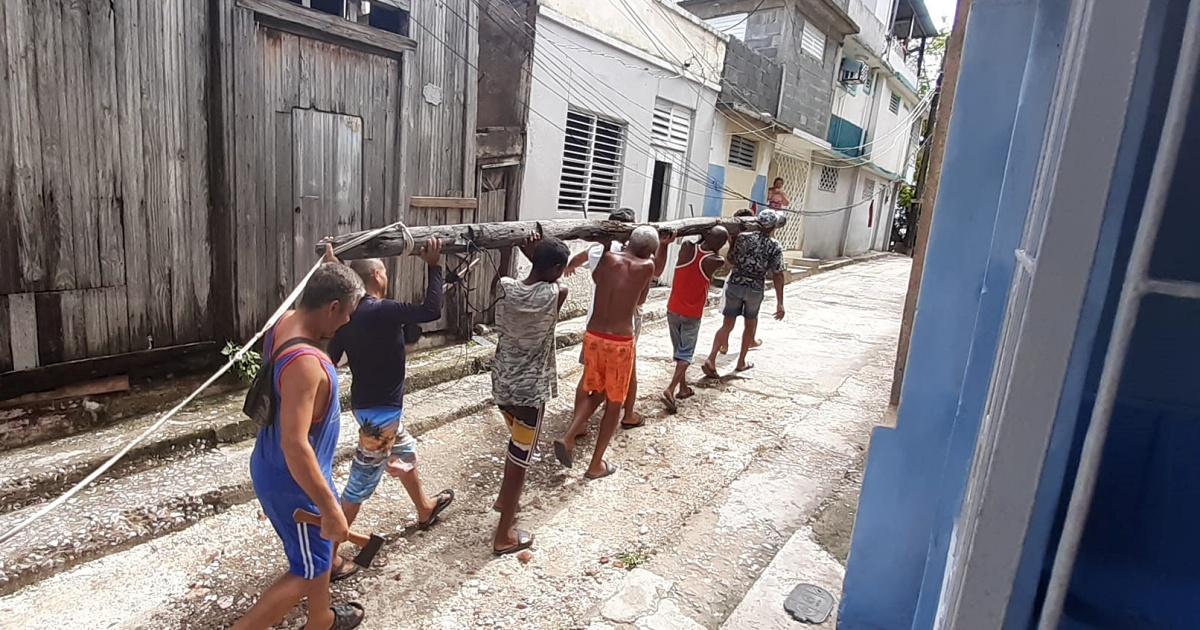 Vecinos de Santiago de Cuba arreglan poste eléctrico © Facebook/Vivian Mendo