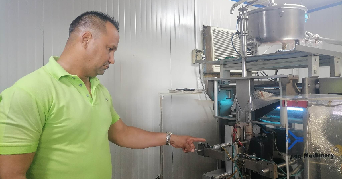 Directivo de la fábrica muestra máquina de envasado en bolsas plásticas © cadenagramonte.cu