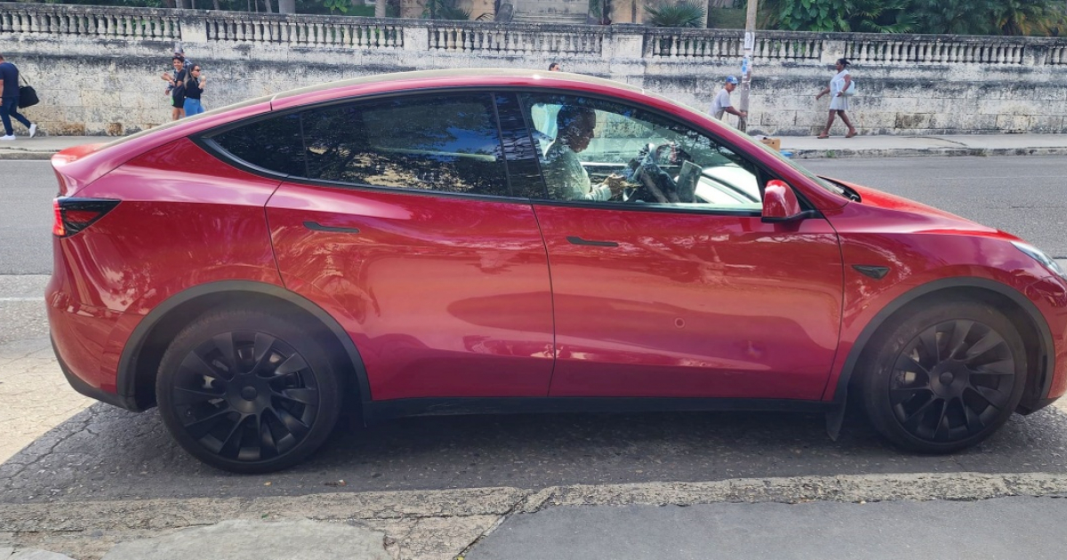 Un Tesla de color rojo visto frente a la Universidad de La Habana © Facebook/Autos Diplomáticos de Cuba