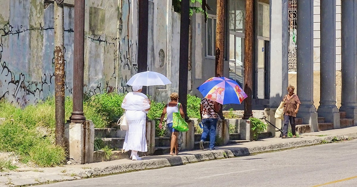 Personas caminando en Cuba con sombrillas (Imagen de referencia) © CiberCuba