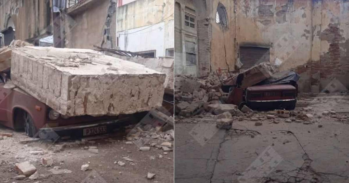 Coche aplastado por muro de almacén en ruinas en Santiago de Cuba