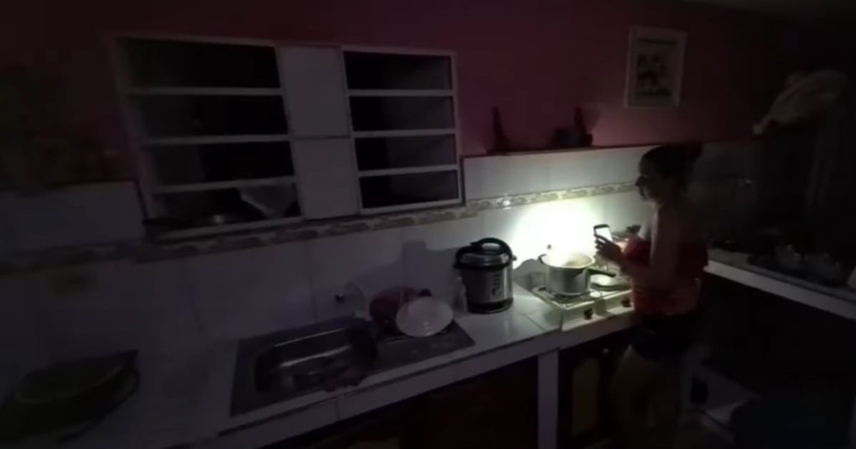 Fotografía conceptual y realista de una ciudad cubana sumida en la oscuridad de un apagón, con siluetas de edificios y un cielo estrellado, simbolizando la constante privación de energía. Estilo cinematográfico, alta definición.