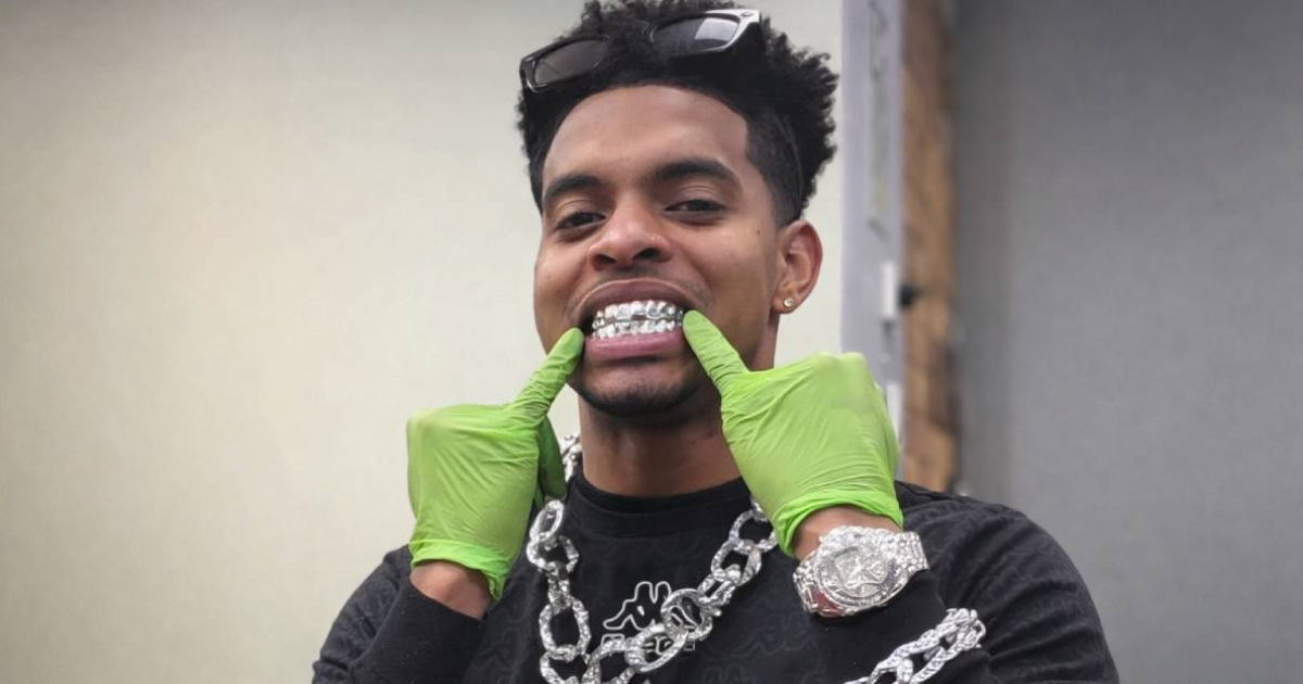 Cuban barber in England sports "chains, watches, and diamonds" while attending to a client from Miami