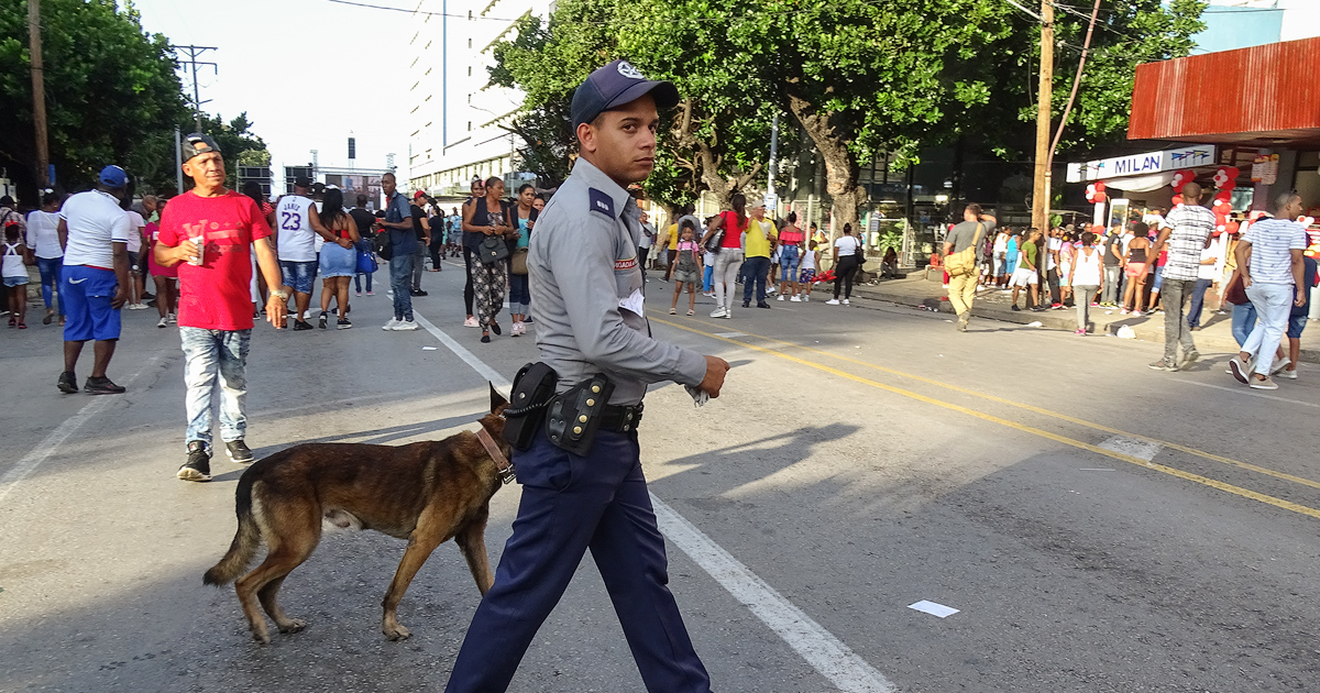 Un policía cruza una calle en Cuba, acompañado por un perro. © CiberCuba