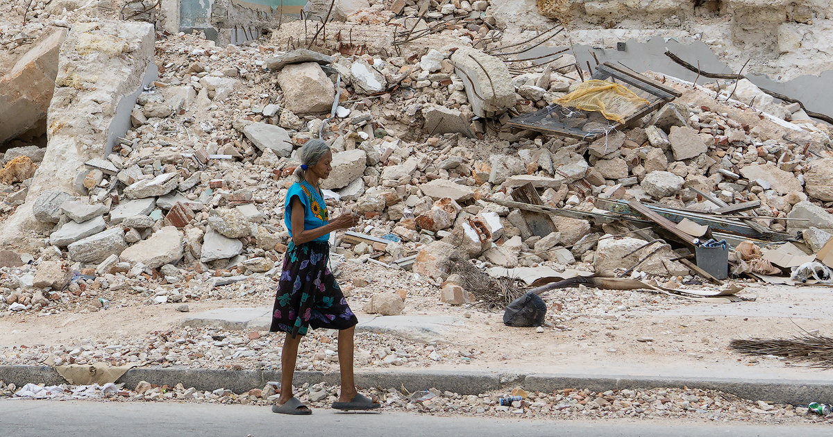 Una anciana camina junto a las ruinas del ISDI, en La Habana © CiberCuba