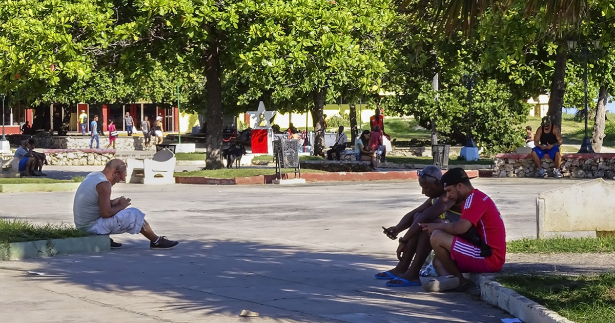 Cubanos intentando conectarse a Internet en un parque © CiberCuba