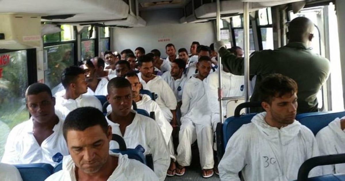 Un autobús, custodiado por un policía de Bahamas, traslada a los balseros cubanos detenidos © 