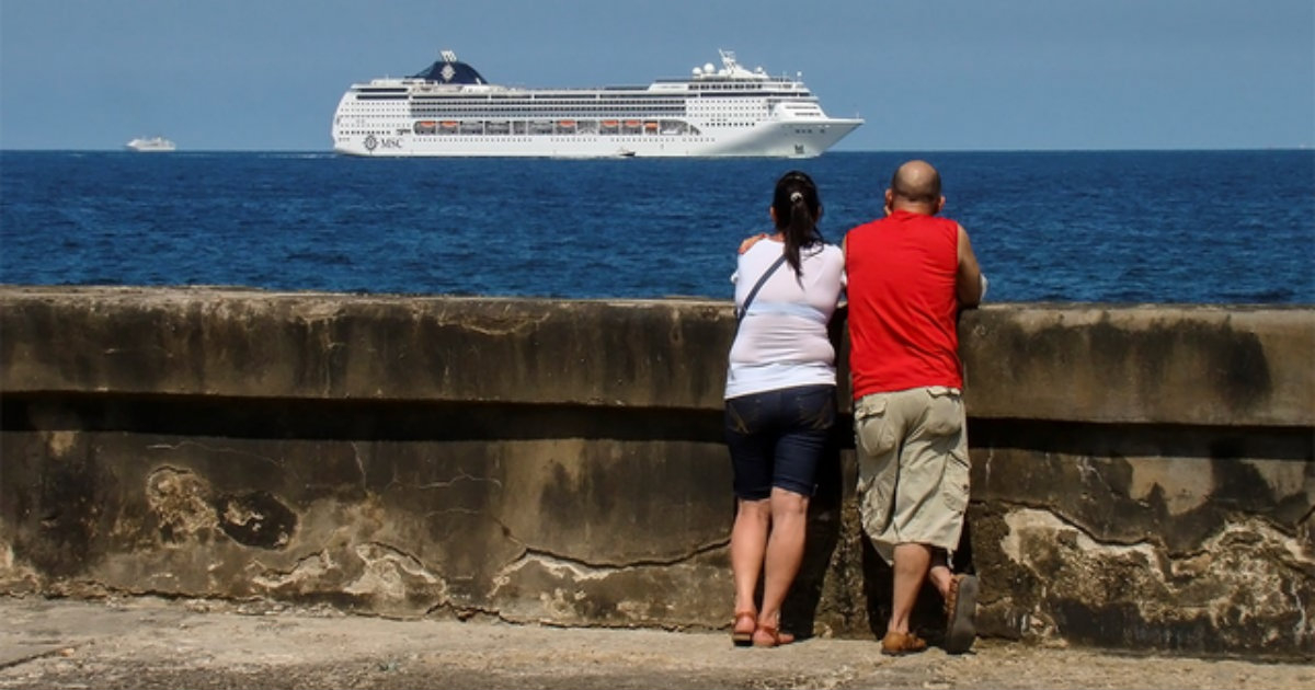 Una pareja, en el Malecón, viendo pasar un crucero. © CiberCuba