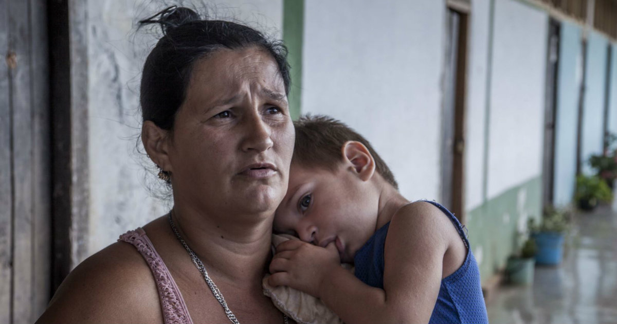 Madre cubana sujeta a su pequeño hijo en brazos © Dan Gabriel / Martí Noticias