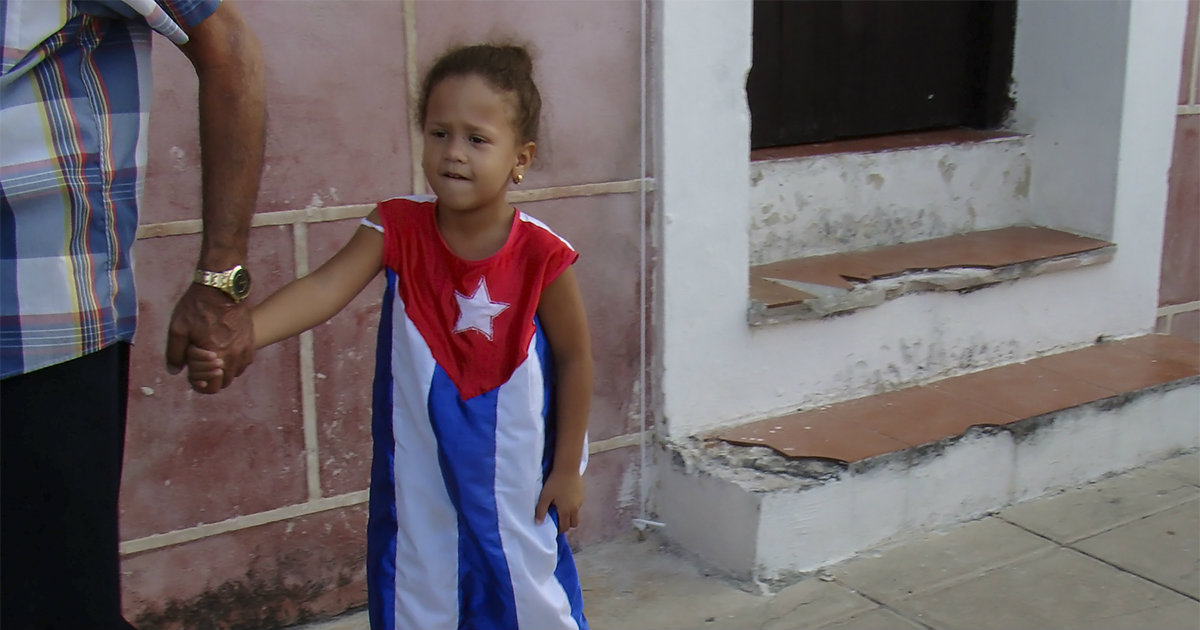 Niña de La Habana enfundada con una bandera de Cuba © CiberCuba