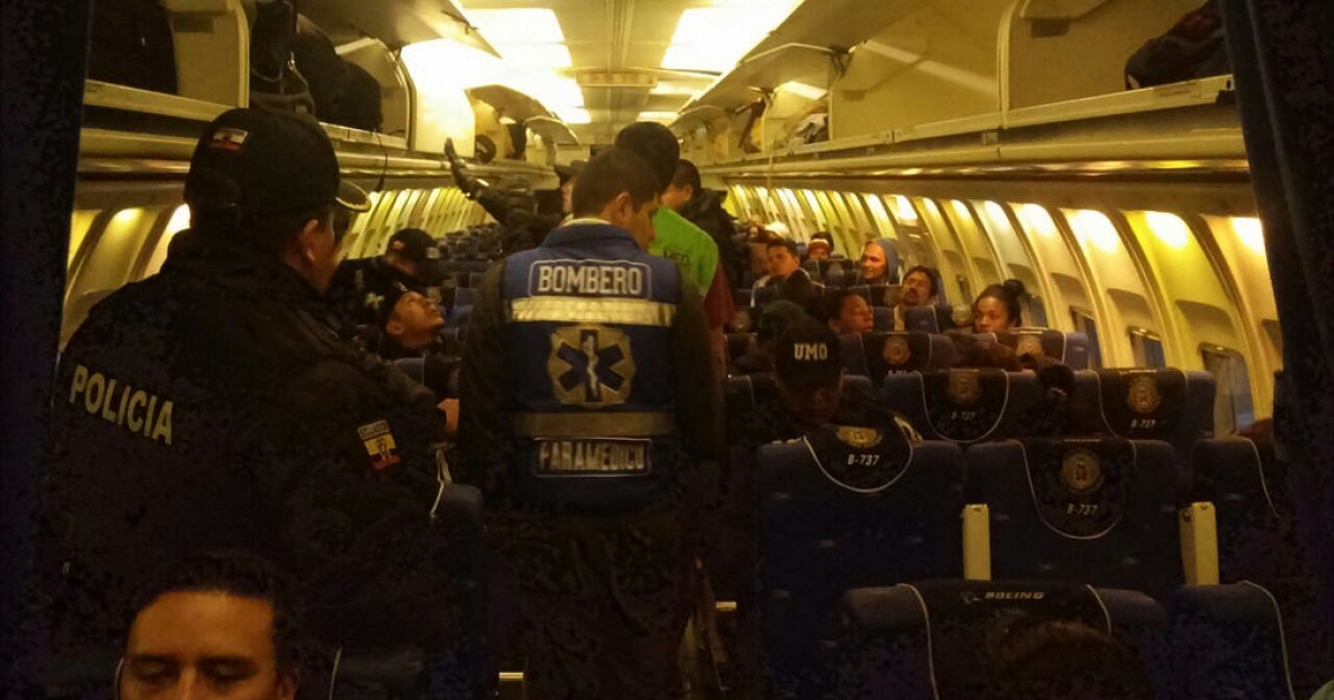 Los bomberos y miembros de seguridad custodian el interior del avión en el que son deportados los migrantes cubanos © 
