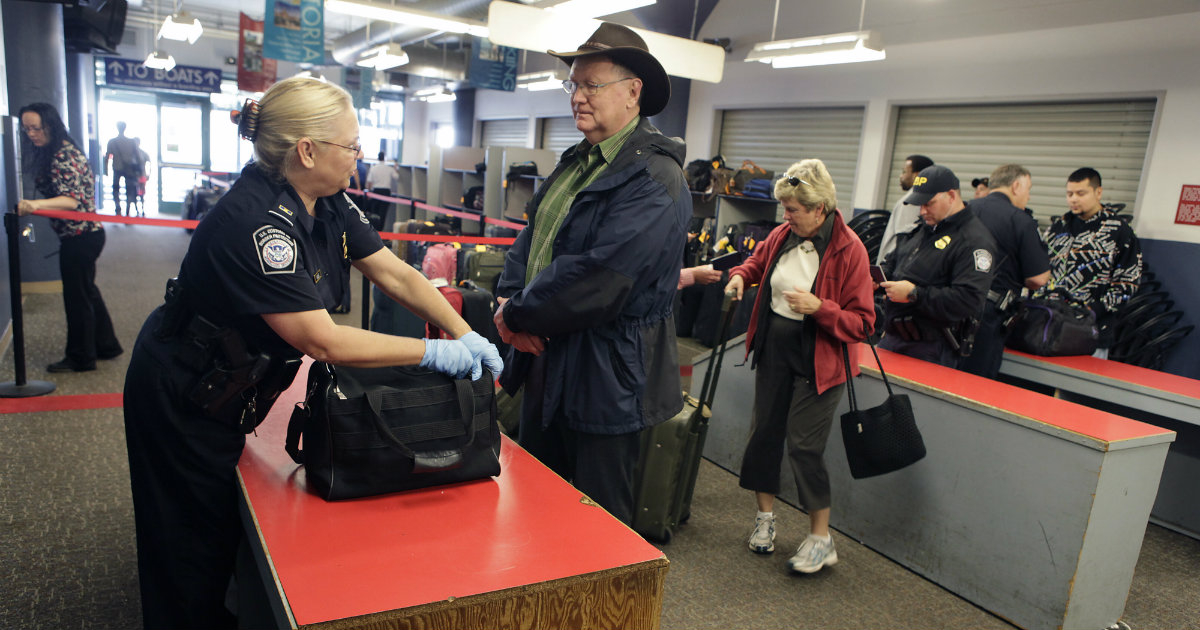 Agente estadounidense inspeccionando una maleta © Flickr / CBP