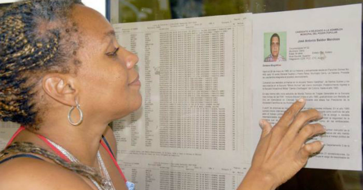 Una cubana ojea una lista electoral © Granma