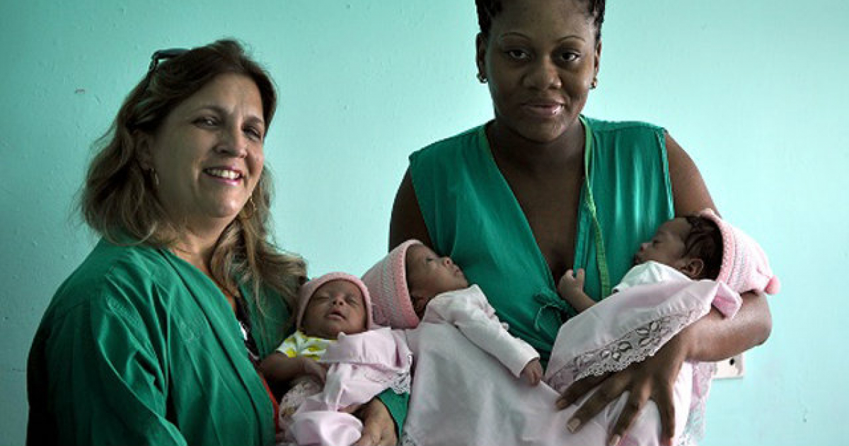 Idelisa Almeida Cáceres con sus hijas en los brazos © Ahora.cu / Elder Leyva