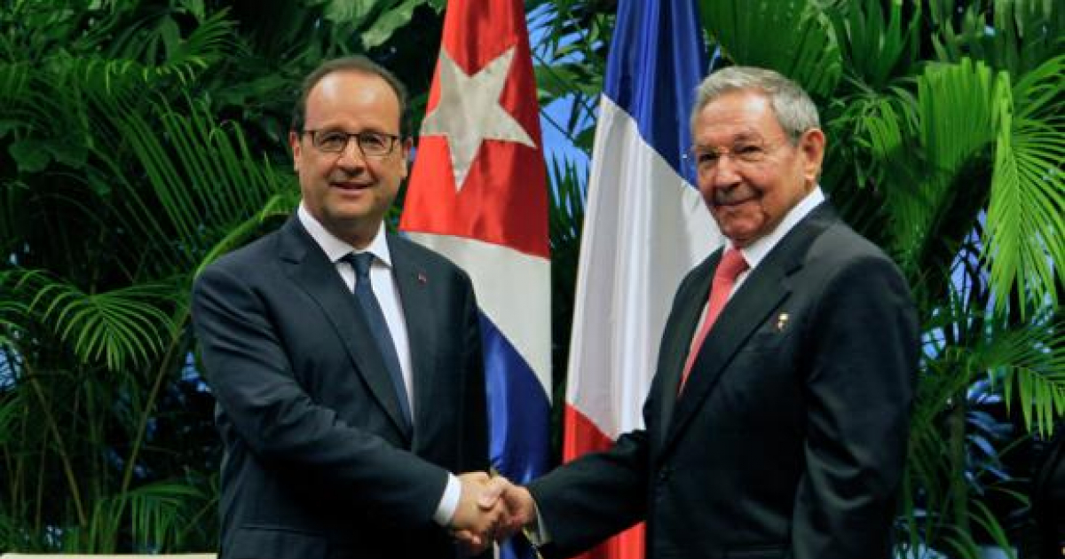 Hollande y Raúl Castro estrechando sus manos con las banderas de fondo © Sputniknews.com
