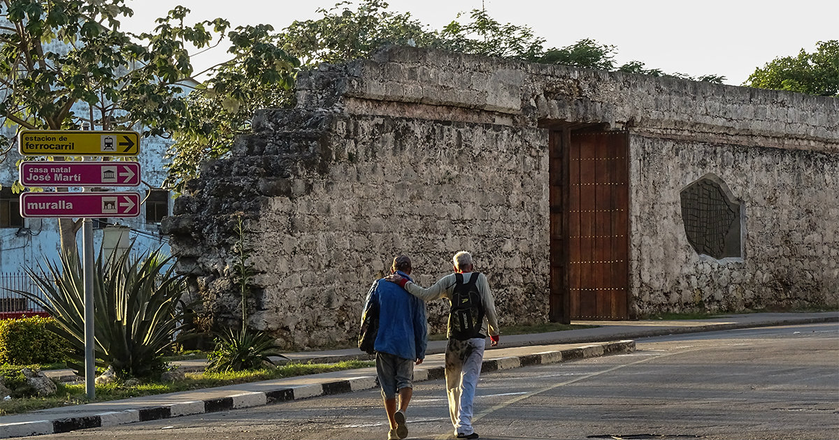 Dos cubanos pasean por la calle. © CiberCuba