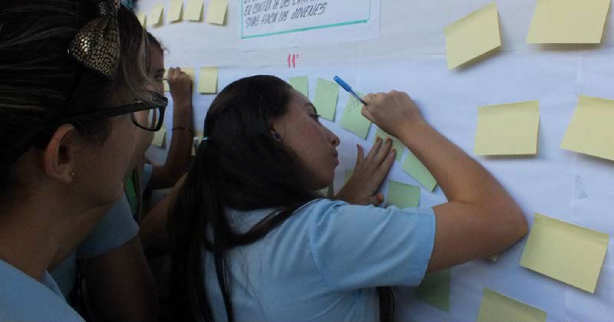 Grupos de estudiantes cubanos escribiendo sobre un panel blanco © Radioangulo / Lisandra Cardoso