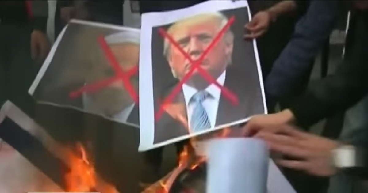 Manifestantes quemando una fotografía de Donald Trump en Oriente Medio © Youtube / Telesur