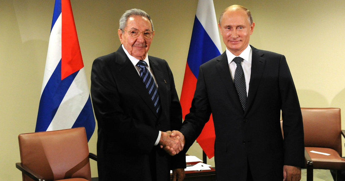 Raúl Castro y Vladimir Putin estrechan sus manos con las banderas de fondo © Wikipedia