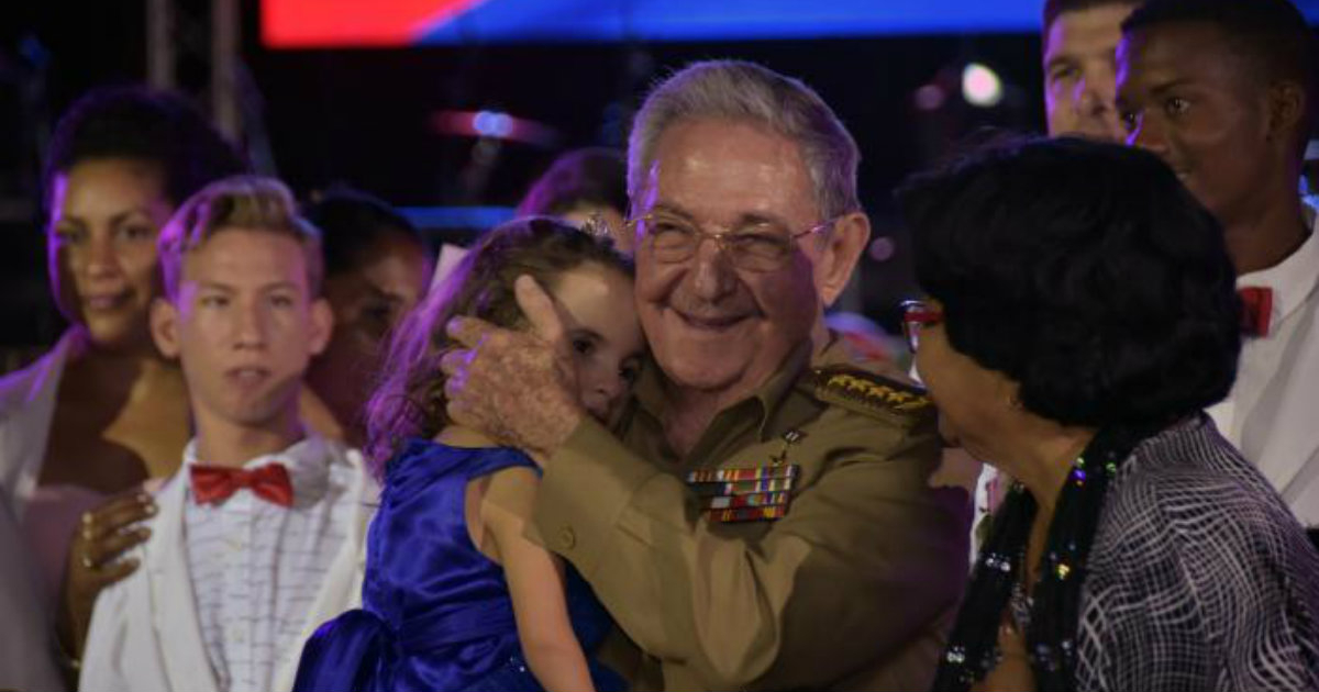 Raúl Castro, con una pequeña en brazos. © Granma.