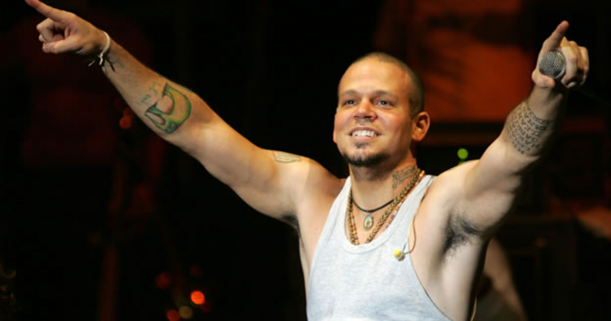 El cantante Residente de Calle 13 extiende los brazos en un concierto © popularresistance.org